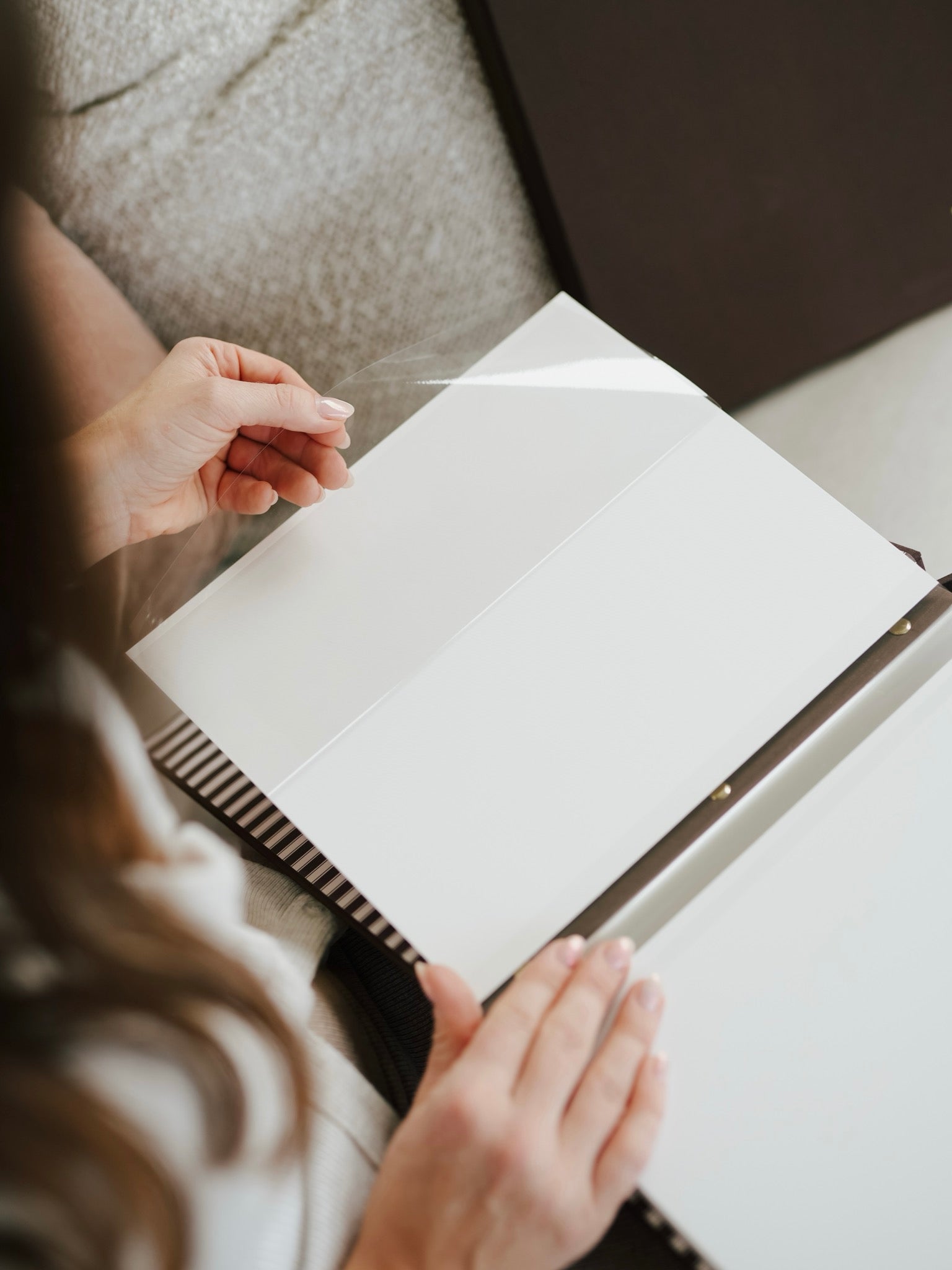 Peeling back the protective film on a self-adhesive album page